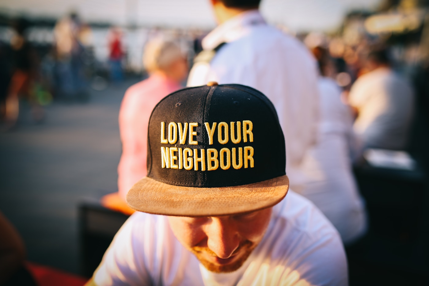 A volunteer wearing a Love Your Neighbour cap while serving in a community